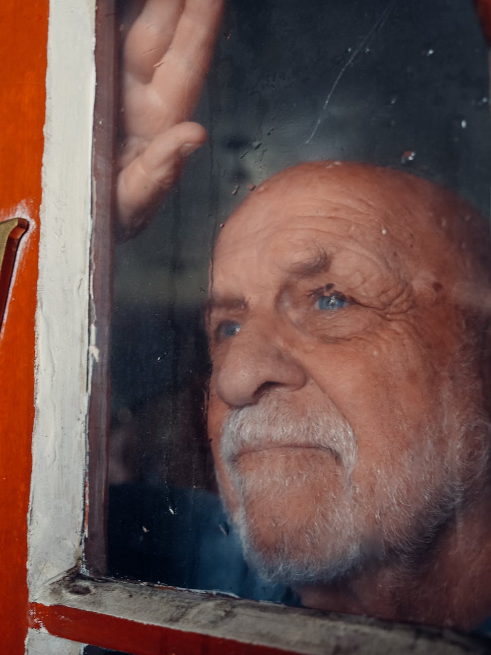 an elderly man behind the glass window